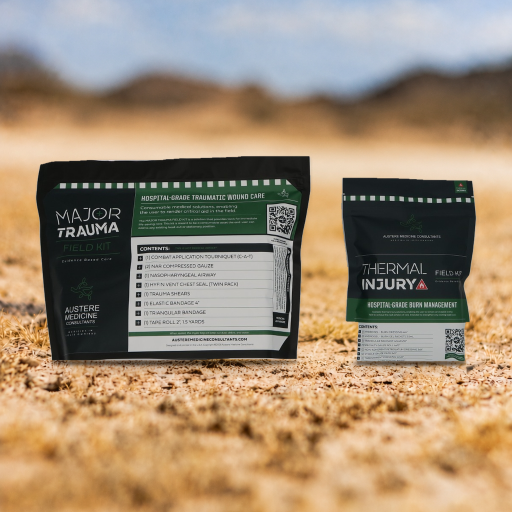 TRAUMA RESPONSE FEILD PACK.  Two product pouches for wound care are displayed on sandy desert ground with a blurred outdoor background. The larger pouch on the left is labeled 'MAJOR TRAUMA' and the smaller pouch on the right is labeled 'THERMAL INJURY'.