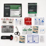 The components of the TRAUMA RESPONSE FIELD PACK.  A comprehensive first aid kit laid out on a white background, containing various medical supplies such as bandages, wound closures, a tourniquet, scissors, and printed instruction sheets.