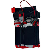 A black emergency first aid pouch with red and gray accents, containing medical tools such as scissors, gauze, and a red tourniquet, shown against a plain white background.